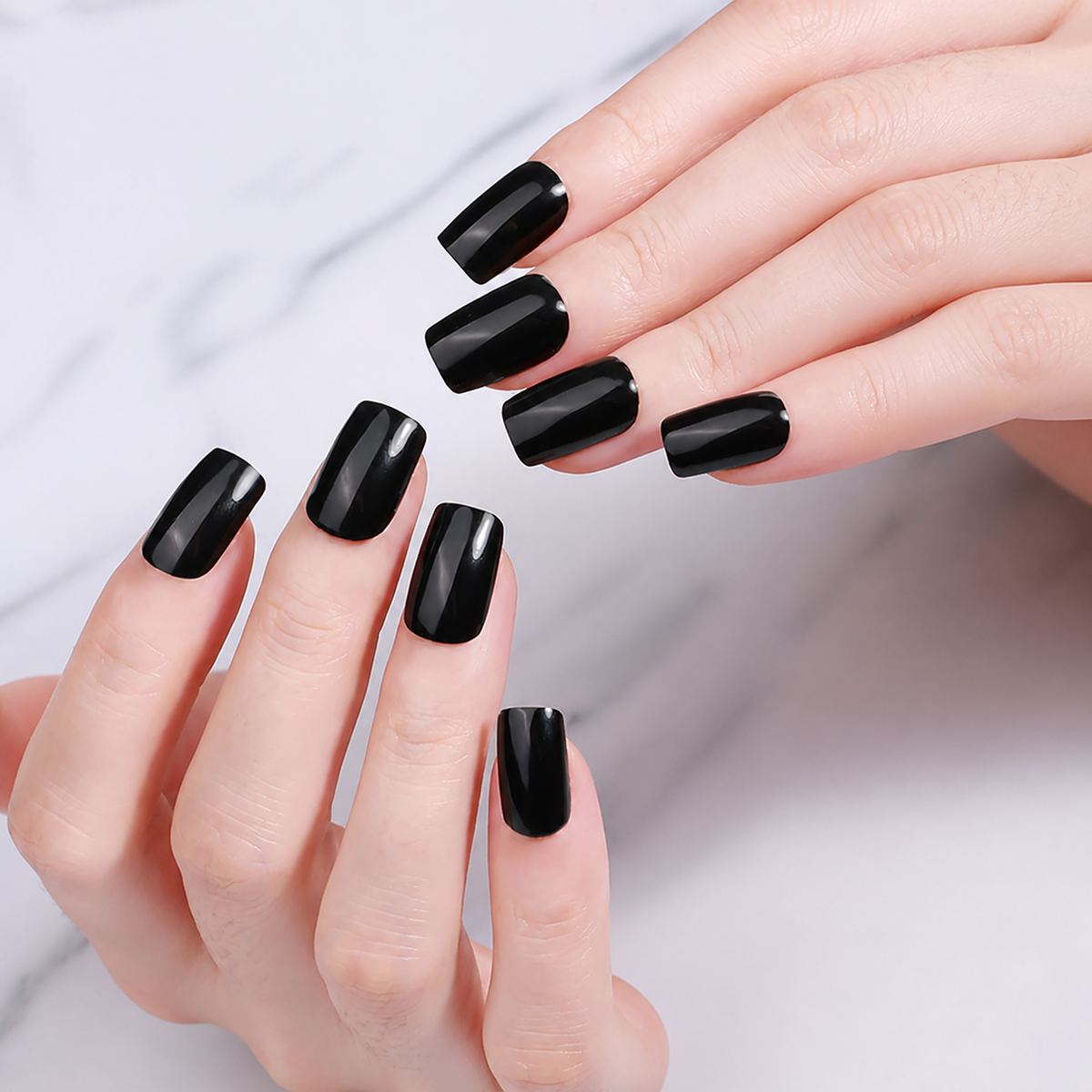 Hand wearing glossy black UV-free gel nail wraps by Stellia Beauty