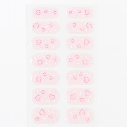 Pattern of pink hearts gel nail wraps on a light pink background by Stellia Beauty