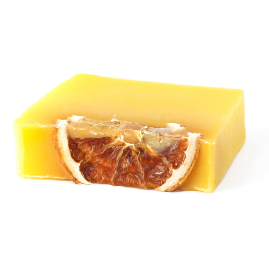 Slice_of_Sunshine_Soap_Slice_by_Stellia_Beauty Yellow soap bar with a slice of dried orange on a white background