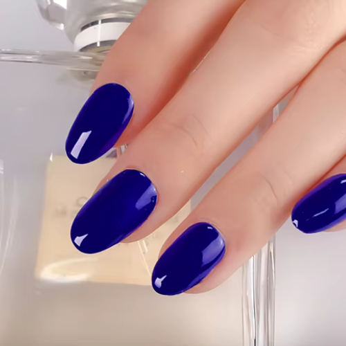 Glossy royal blue gel-effect nail wraps on hand – bold and elegant manicure look