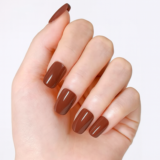 Hand with brown gel nail wraps on a light background by Stellia Beauty