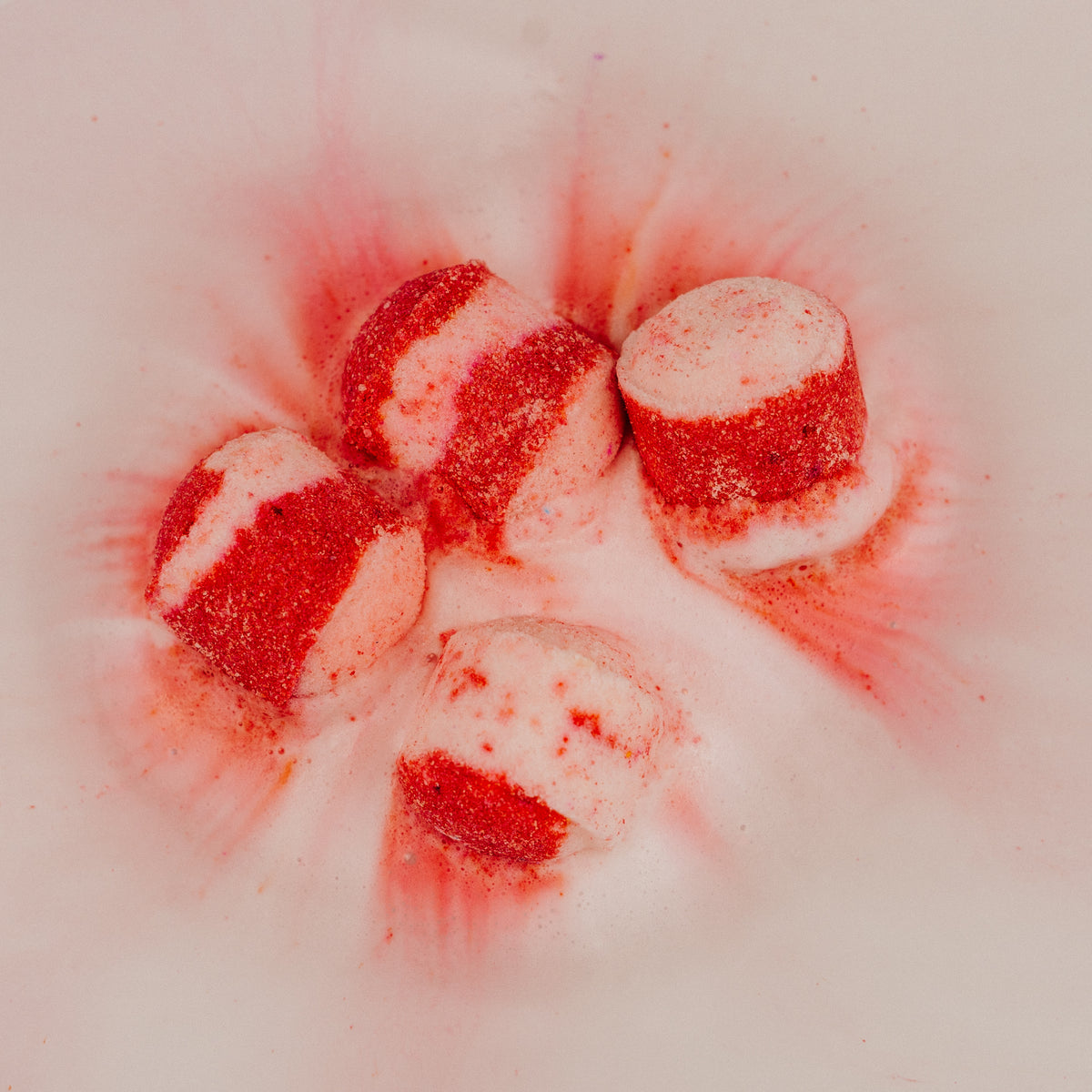 Red and white striped candy bath bombs on a white background Stellia Beauty