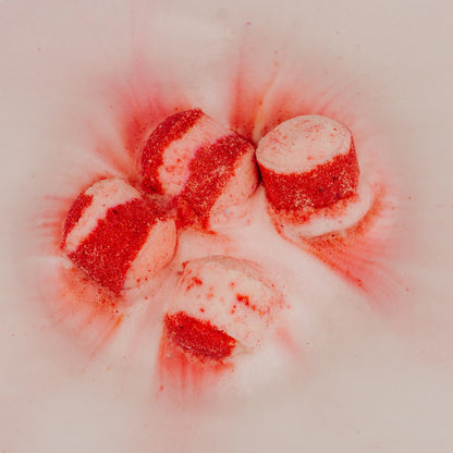Red and white striped candy bath bombs on a white background Stellia Beauty