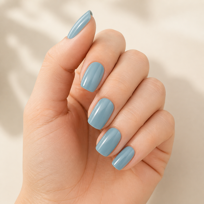 Hand wearing glossy grey-blue semi-cured gel nail wraps by Stellia Beauty