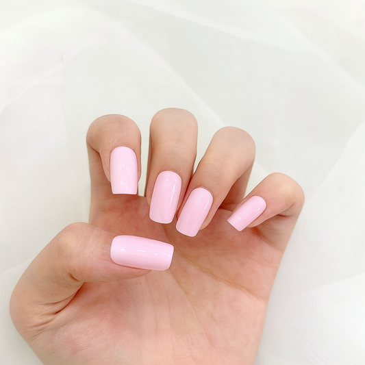 Hand with light pink gel nail wraps on a white background by Stellia Beauty