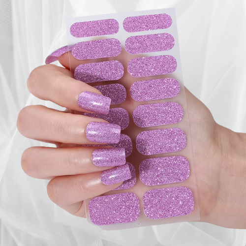 Hand displaying sparkling lilac glitter nail wraps with matching wrap sheet – vibrant and glamorous manicure