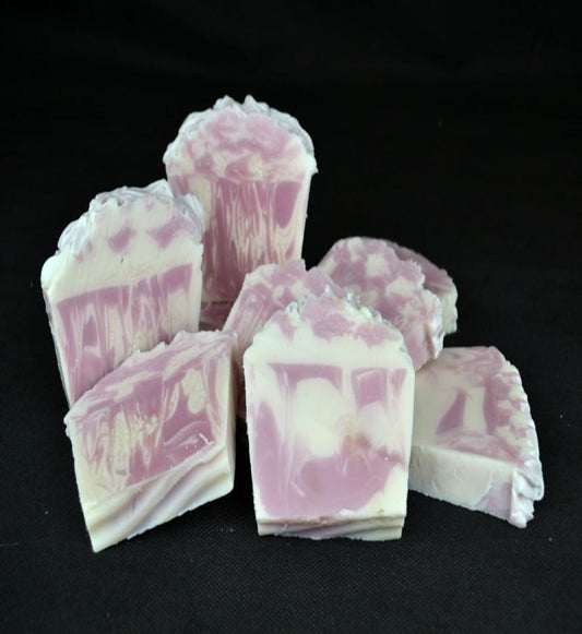 Pink and white marbled soap bars on a black background