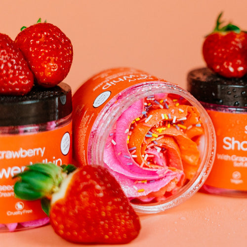 Jars of strawberry whipped soap with strawberries on a peach background by Stellia Beauty