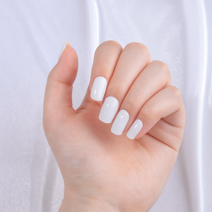 Hand wearing white fully cured gel nail wraps on a light background by Stellia Beauty